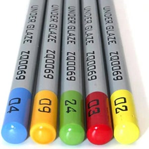 May include: Five gray ceramic pencils with colorful tips. The pencils are labeled "UNDER GLAZE ZQ0069" and have blue, yellow, green, red, and yellow tips with the numbers Q4, Q9, 24, Q3, and Q2.