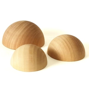 May include: Three wooden half-sphere shapes of varying sizes. The spheres are made of light brown wood with a smooth, polished finish.