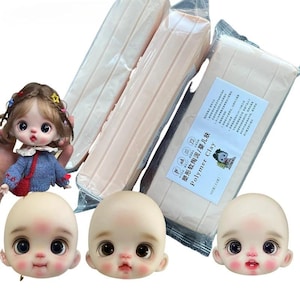 Puede incluir: Un conjunto de materiales para hacer muñecas. La imagen muestra tres cabezas de muñeca con rasgos pintados y varios paquetes de arcilla polimérica. Las cabezas de las muñecas tienen ojos grandes y mejillas rosadas. La arcilla es de color melocotón claro y está etiquetada como "Polymer Clay".