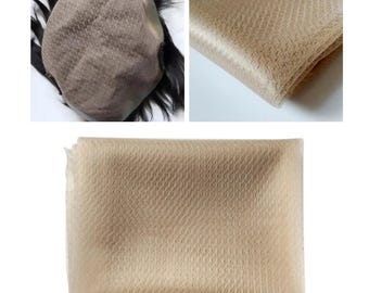 May include: A close-up of a light brown hairpiece with a mesh base. The mesh is visible in the image. The hairpiece is designed to be used for hair replacement.