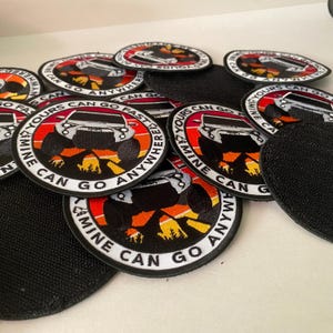 Puede incluir: Primer plano de varios parches redondos bordados con fondo blanco y texto negro. Los parches presentan una silueta de un jeep con un fondo de puesta de sol y el texto "Mine Can Go Anywhere Yours Can Go Fast".