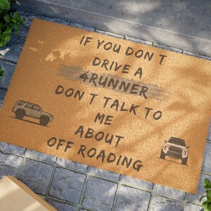 Könnte beinhalten: Eine braune Fußmatte mit dem Text "IF YOU DON'T DRIVE A 4RUNNER DON'T TALK TO ME ABOUT OFF ROADING". Es befinden sich zwei Illustrationen eines 4Runner auf der Fußmatte.
