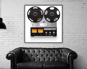 May include: A reel-to-reel tape recorder featuring two large black circular reels mounted on a silver and black metallic chassis. The device includes two illuminated orange analog VU meters, multiple control knobs, and various switches.