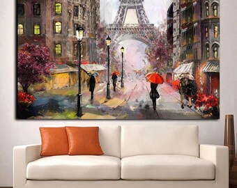 May include: A rectangular wall art print depicting a rainy Parisian street scene with the Eiffel Tower in the background. The painting features tall buildings, black street lamps, and several figures walking with red and neutral coloured umbrellas.