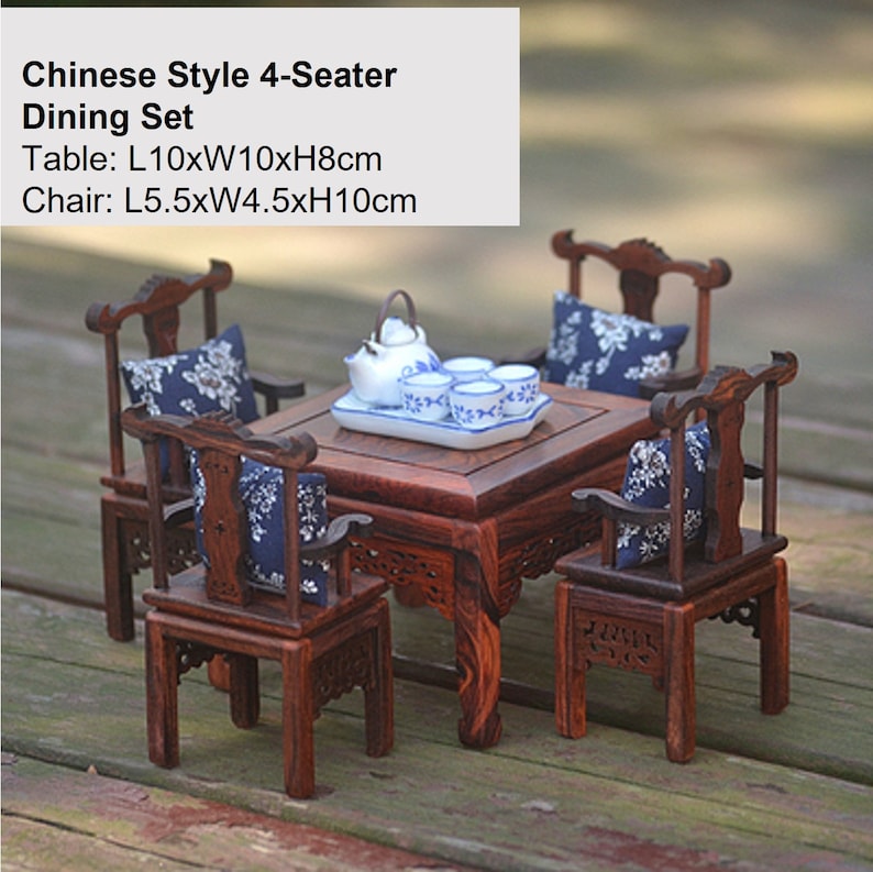 Puede incluir: Un juego de comedor de estilo chino en miniatura con una mesa de madera oscura y cuatro sillas. La mesa mide 25,4 cm de largo, 25,4 cm de ancho y 20,3 cm de alto. Cada silla mide 14 cm de largo, 11,4 cm de ancho y 25,4 cm de alto. El juego incluye una tetera y cuatro tazas de t&eacute; con un dise&ntilde;o floral azul y blanco.