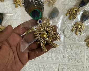 Broche tradicional devocional de Krishna con pluma de pavo real, metal dorado, diseño de flauta.