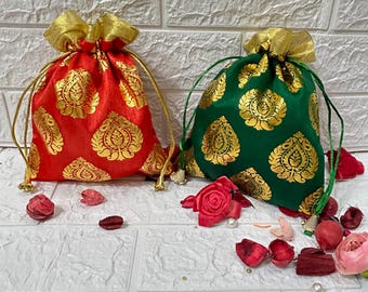 Könnte beinhalten: Zwei kleine Kordelbeutel mit goldenen Verzierungen und einem goldenen Muster. Ein Beutel ist rot mit goldenen Akzenten und der andere ist grün mit goldenen Akzenten.