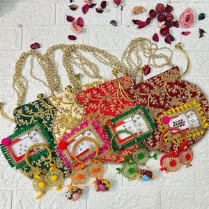 May include: An assortment of embroidered purses in green, cream, and red, adorned with gold thread and beaded straps. Each purse features a framed image and is accompanied by matching jewelry, including bracelets and earrings. The items are arranged on a white surface.