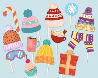 May include: A collection of winter-themed props on sticks, including hats, a scarf, a candy cane, a mug of hot chocolate, and a gift box. The props are in various colors, such as red, orange, yellow, and blue, with decorative patterns.