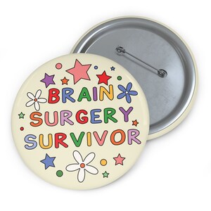 May include: A round button with a cream background and colourful text that reads "Brain Surgery Survivor". The text is surrounded by colourful stars and flowers.