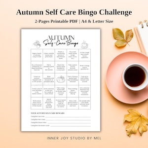 Könnte beinhalten: Ausdruckbares Herbst-Self-Care-Bingo. Die Bingokarte enthält Self-Care-Aktivitäten wie das Genießen eines warmen Getränks, den Besuch eines Kürbisfelds und das Aufschreiben von Dingen, für die man dankbar ist. Enthält eine Tasse Kaffee und Herbstblätter.