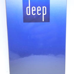 Op de afbeelding: Een rechthoekige doos van Davidoff Cool Water Deep Eau de Toilette. De doos heeft een blauw gradiëntontwerp met het woord 'deep' in het wit. De onderkant van de doos geeft 100 ml aan.