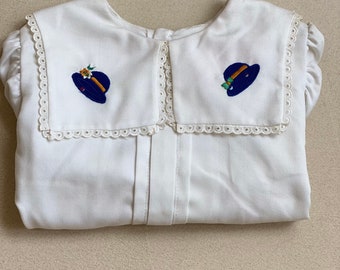 5/6 years - White 80s vintage blouse, long sleeves, new from stock with broad embroidered neckpiece portraying blue hats and frontal pleats