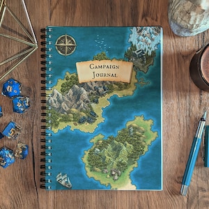 May include: A blue and green spiral bound notebook with a map and the words "Campaign Journal" on the cover. There are blue dice and a blue and silver pen on a wooden surface.