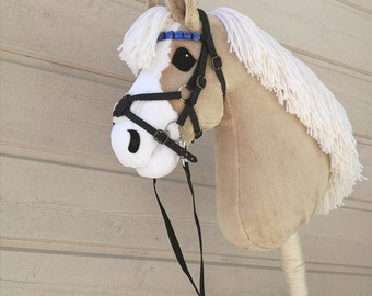 Beige hobbyhorse with a white blaze and muzzle. Made from smooth minky fabric. True artesan product of finnish hobbyhorse whisperer, Jenny S