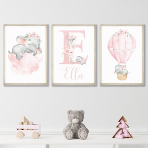 May include: Three pink and gray nursery prints featuring a sleeping elephant on a cloud, a hot air balloon with elephants, and a floral letter E with the name Ella.