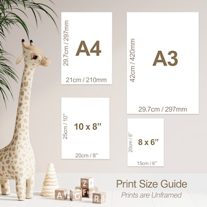 May include: Print size guide for unframed prints in various sizes, including 8x6 inches, 10x8 inches, A4, and A3. The guide is displayed on a light beige wall with a stuffed giraffe toy and wooden blocks in the foreground.