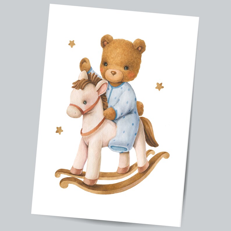 Op de afbeelding: Een bruine teddybeer in een blauwe en witte pyjama rijdt op een wit schommelpaard met bruine houten wiegen. De achtergrond is wit met kleine gouden sterren.