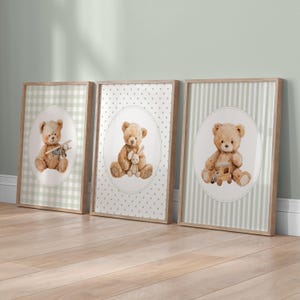 May include: Three framed prints featuring watercolor teddy bears. Each bear is inside an oval, with different backgrounds: a green and white gingham, a white dotted pattern, and green and white stripes. The bears hold a toy airplane, a bunny, and a toy train.