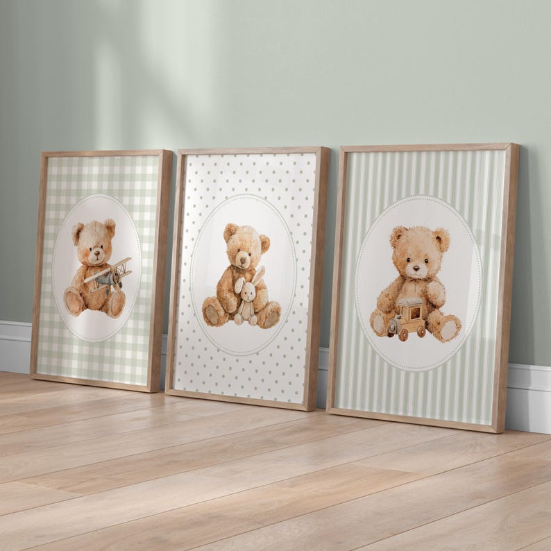 May include: Three framed prints featuring watercolor teddy bears. Each bear is inside an oval, with different backgrounds: a green and white gingham, a white dotted pattern, and green and white stripes. The bears hold a toy airplane, a bunny, and a toy train.