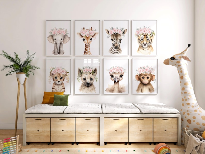 May include: A set of eight framed prints featuring watercolour illustrations of various animals wearing flower crowns. The animals include an elephant, giraffe, zebra, tiger, cheetah, ostrich, monkey, and hyena. The prints are displayed on a white wall above a wooden storage bench.