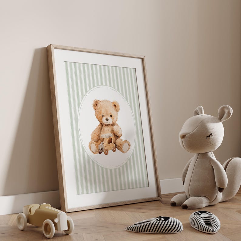 May include: A framed print featuring a watercolor illustration of a teddy bear holding a wooden toy train. The background has vertical stripes in light green and white. A stuffed squirrel and toy car are on the floor.