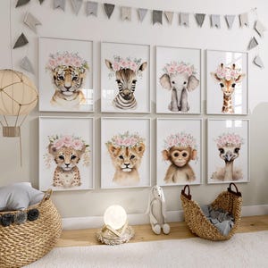 May include: A set of eight watercolour animal prints featuring various animals wearing flower crowns. The prints are framed in white and arranged in a grid on a white wall. The animals include a zebra, a lion, a giraffe, an elephant, a monkey, an ostrich, and two leopards.