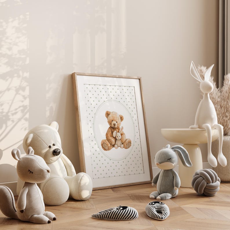May include: A framed print featuring a watercolor illustration of a teddy bear holding a smaller stuffed animal. The image is surrounded by plush toys, including a white bear, a gray squirrel, and a gray bunny. Decorative items include a white rabbit figurine and a gray knot.