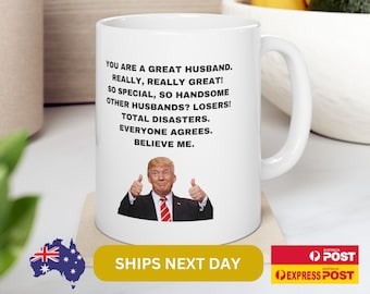 May include: White ceramic coffee mug with a black and white image of a man with a thumbs up gesture. The text on the mug reads: "You are a great husband. Really, really great! So special, so handsome. Other husbands? Losers! Total disasters. Everyone agrees. Believe me."
