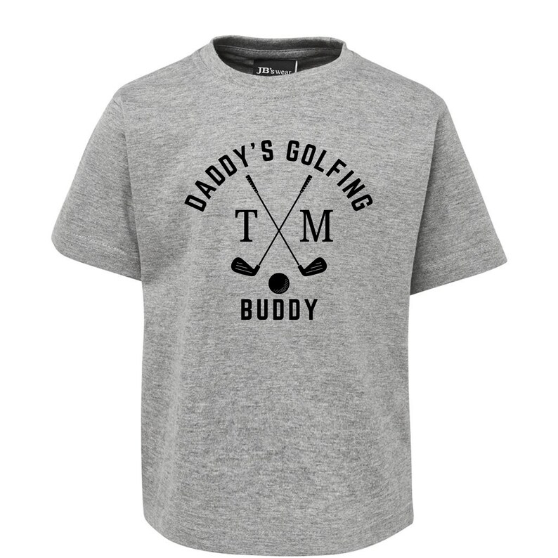 May include: Grey short-sleeved t-shirt with black text that reads "Daddy's Golfing TM Buddy" with a graphic of two crossed golf clubs and a golf ball.