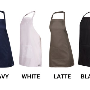 May include: Four different colored aprons with a single pocket. The aprons are navy, white, latte, and black.