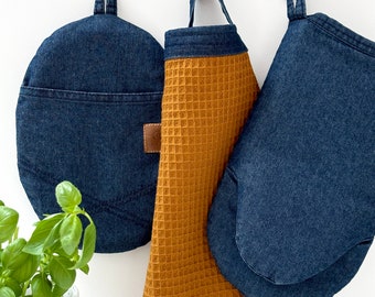 Juego de manopla de cocina y agarradera de mezclilla con paños de cocina marrones.