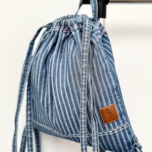 Boho denim drawstring bag, hanging on short strap from back