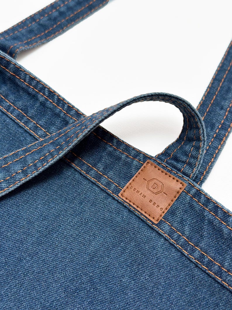 May include: A blue denim tote bag with a brown leather patch that says "Denim Deko" and a stylized "D" logo.