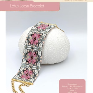 May include: A beaded Lotus Loom bracelet with pink, gray, and white floral patterns. The bracelet is approximately 1.4 x 5.2 inches. The design is by Karen Adendorff. The image also includes the text "Lotus Loom Bracelet" and "Hanki Dori".