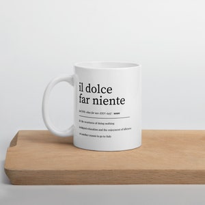 May include: White ceramic mug with a black design that reads "il dolce far niente" and defines the phrase as "the sweetness of doing nothing, indulgent relaxation and the enjoyment of idleness, yet another reason to go to Italy."