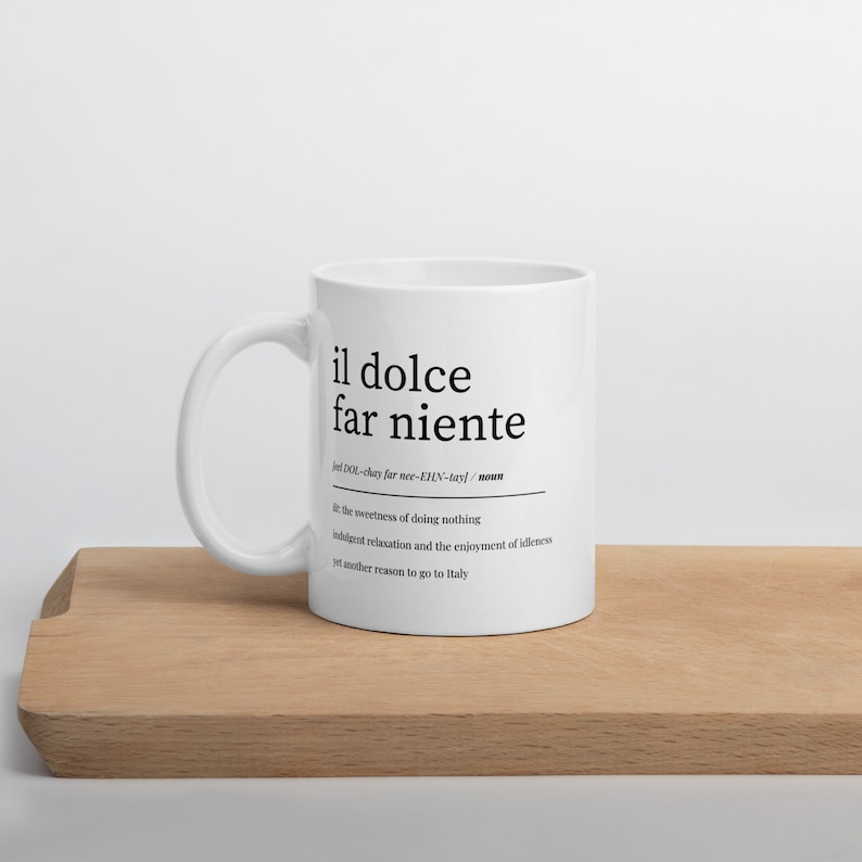 May include: White ceramic mug with a black design that reads "il dolce far niente" and defines the phrase as "the sweetness of doing nothing, indulgent relaxation and the enjoyment of idleness, yet another reason to go to Italy."