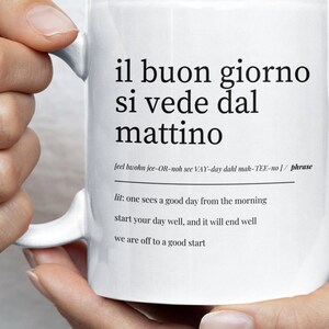 white ceramic mug with italian quote il buon giorno si vede dal mattino held in hand