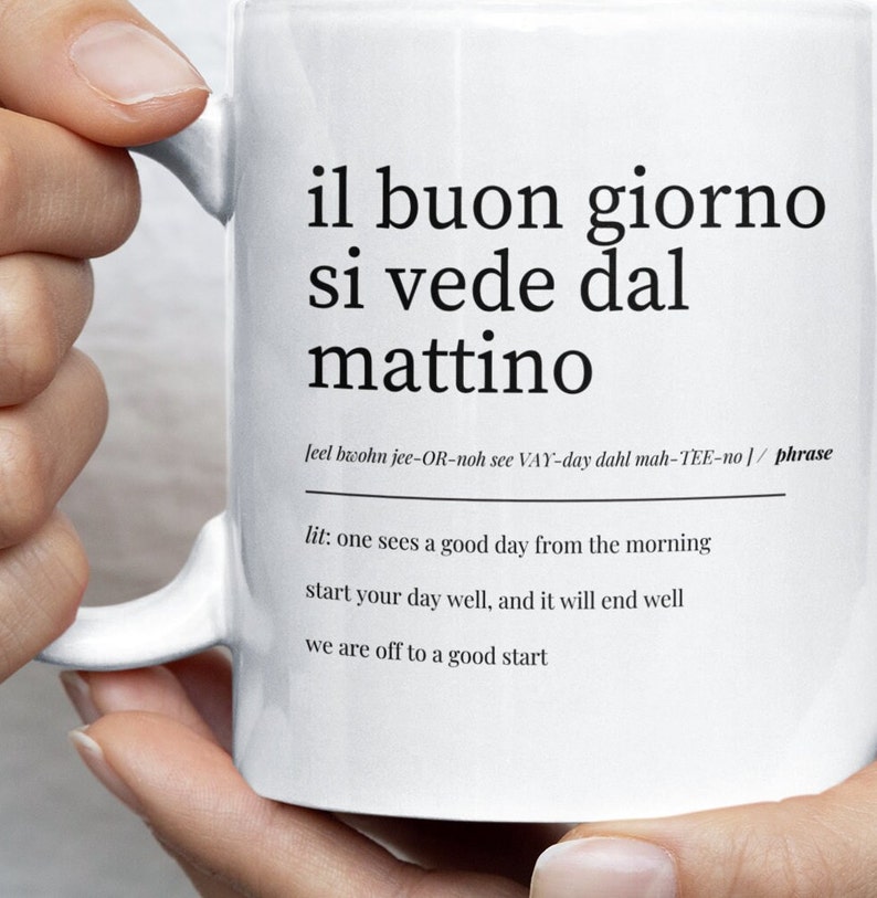 white ceramic mug with italian quote il buon giorno si vede dal mattino held in hand