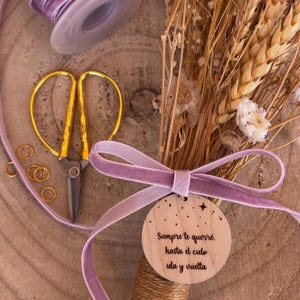 Puede incluir: Una etiqueta redonda de madera con fondo marrón claro y texto blanco que dice "Siempre te querré, hasta el cielo ida y vuelta". La etiqueta está atada con una cinta de terciopelo morado claro y una pequeña estrella dorada.