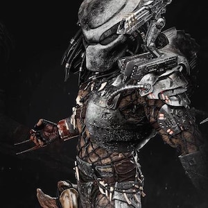 Peut inclure: Gros plan d'une figurine d'action Predator. La figurine porte une combinaison noire et argentée avec un casque et des armes détaillés. La figurine est posée dans une pose d'action dynamique.