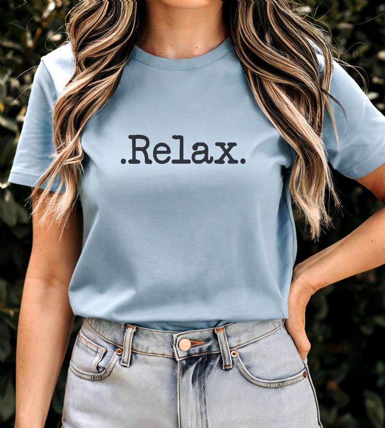 May include: A light blue t-shirt with a black graphic that says ".Relax."
