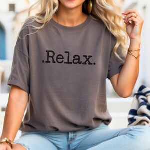 May include: A grey t-shirt with the word "Relax." printed in black on the front.