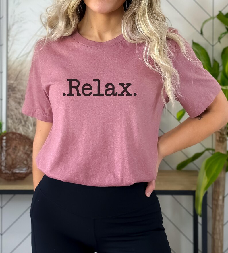 May include: A mauve short-sleeved t-shirt with the text ".Relax." printed in black.