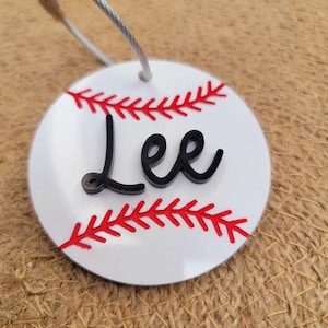 May include: A white ceramic mug with a black handle and the text "But First, Coffee" in a bold, black font. The mug is set against a blurred background, suggesting a cozy setting.