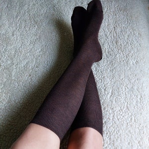 May include: A pair of brown knee-high socks with a ribbed texture.