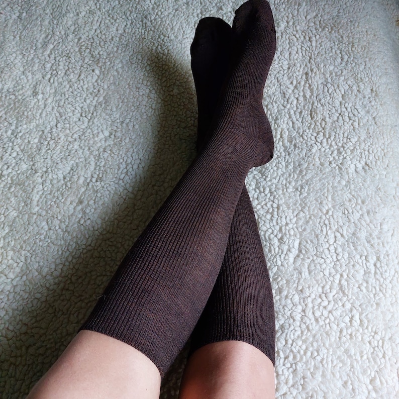 May include: A pair of brown knee-high socks with a ribbed texture.
