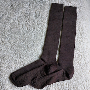 May include: A pair of brown knee-high socks made of a soft, textured material.