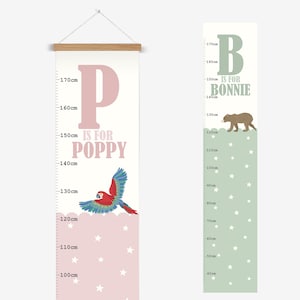 Puede incluir: Dos tablas de altura rosa y verde con estrellas blancas. La tabla rosa tiene una letra "P" grande y el texto "IS FOR POPPY" con un loro rojo y azul. La tabla verde tiene una letra "B" grande y el texto "IS FOR BONNIE" con un oso marrón. Ambas tablas tienen medidas en centímetros.