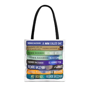 May include: White tote bag with black handles featuring a stack of Fredrik Backman book titles. Titles include "A Man Called Ove", "Britt-Marie Was Here", and "Us Against You". The bag has a clean, minimalist design.